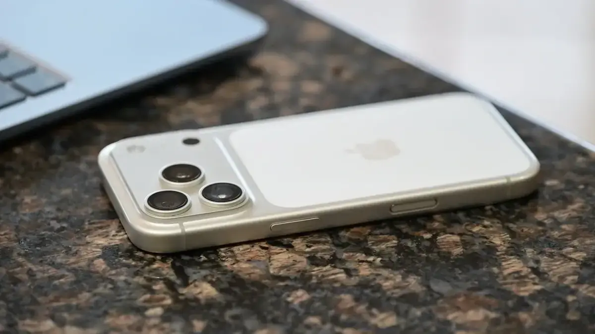 机に伏せて置かれたiPhone 17 Pro Maxの背面。横長のカメラ台座と3つのレンズが並んで見える