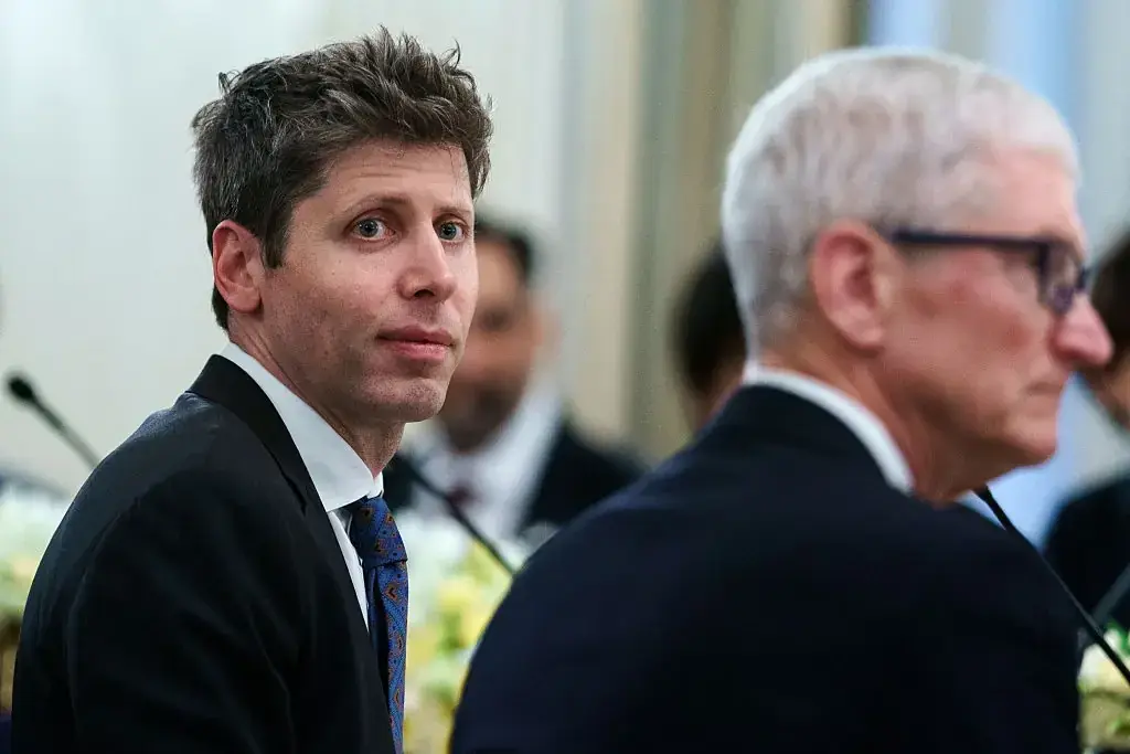 食事の席で、左手前にOpenAIのサム・アルトマンCEO、右手前にメガネをかけたAppleのティム・クックCEOが並んで座っている