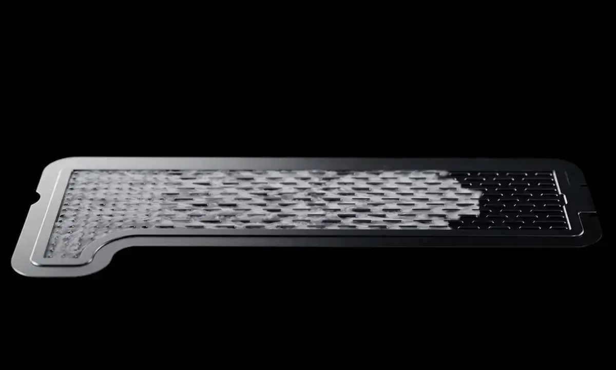 黒い背景に置かれた、細長い金属製のベーパーチャンバー冷却プレート。表面に液体が流れるような網目状の内部構造が見える