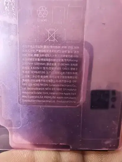 紫の保護フィルム越しに写ったバッテリーの規制表示。3.907V 5391mAh 21.063Wh、型号126ES、製造元としてSunwoda Electronic Co., Ltd. Second Branchの名前が中国語の警告文とともに並んでいる