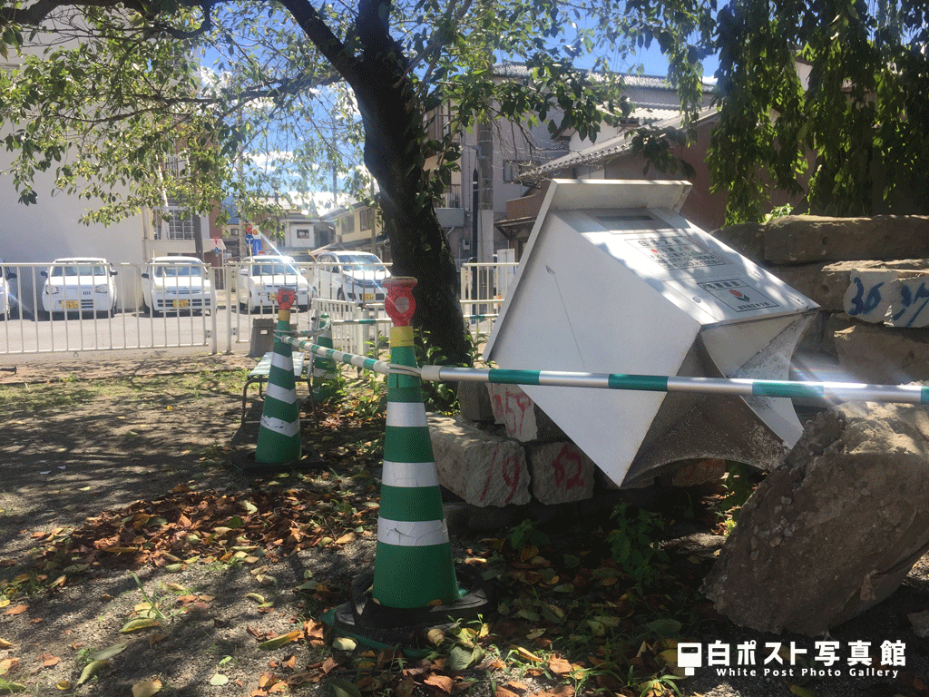 倒壊する三角公園の白ポスト