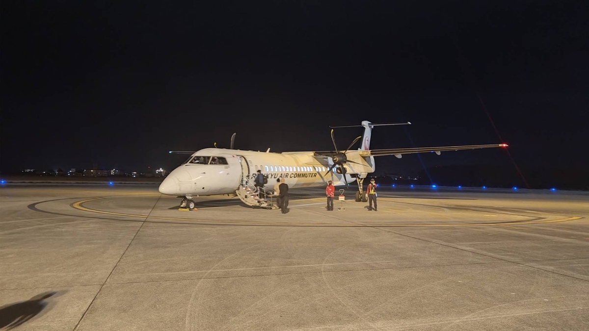 宮古発那覇行きの最終便となる飛行機の写真。乗客がタラップを登りプロペラ機へ乗り込む様子。