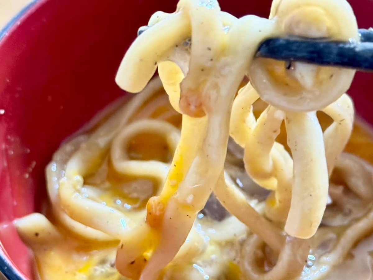 生卵に麺をつけた写真
