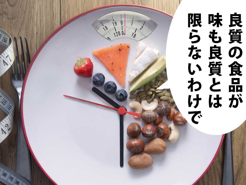体重計を模した皿の上に時計の針があり、果物やナッツが並ぶ。吹き出しには「良質の食品が味も良質とは限らないわけで」