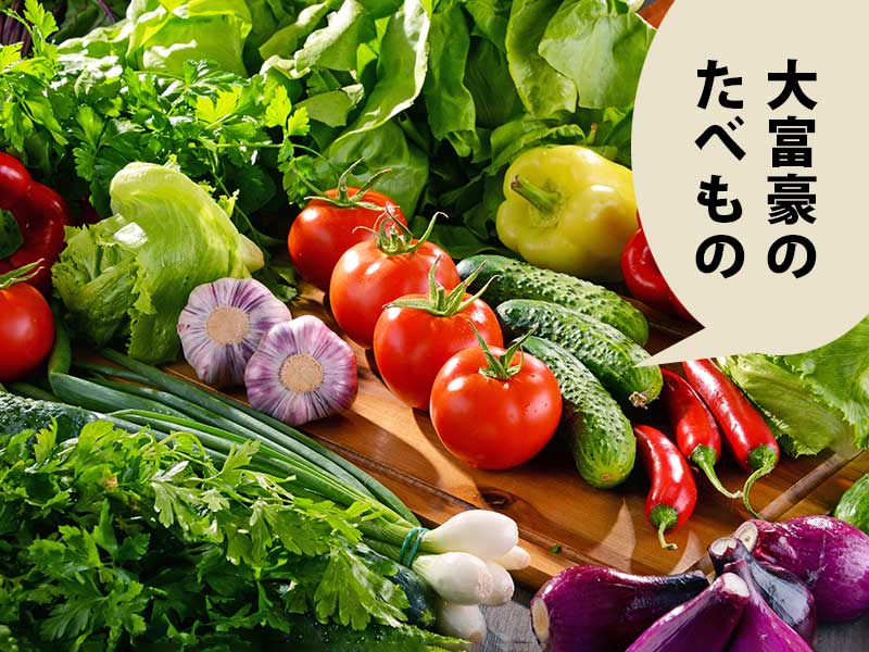 トマトやきゅうり、葉野菜といった色鮮やかな野菜が並んでいる。吹き出しに、『大富豪のたべもの』