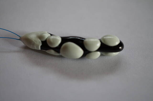 Raised resin sections form the shell-like finish on a twisted ceramic example.