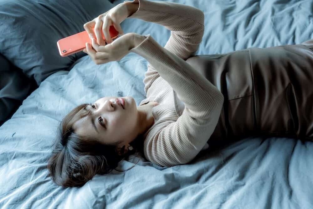 スマホを見ながら悩んでいる若者の様子