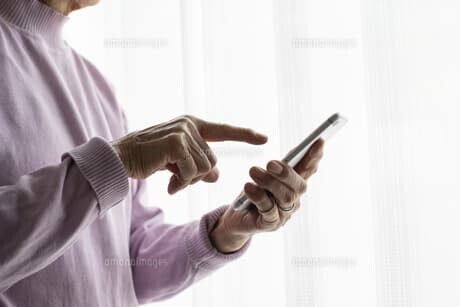 スマートフォンを操作する高齢者
