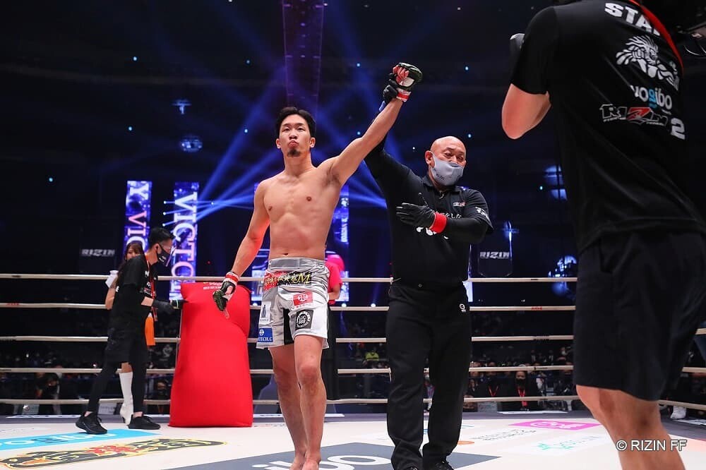 血まみれの激闘を制し勝利ポーズを決める朝倉未来の姿