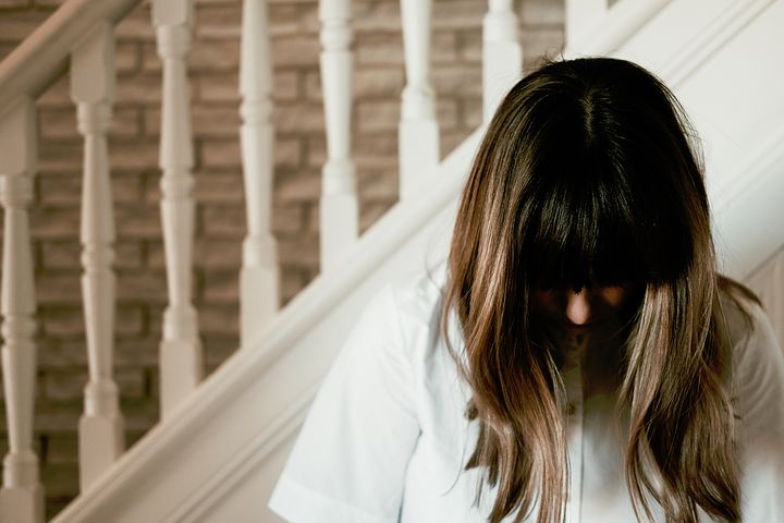 前髪豊富な下向きの女性の写真