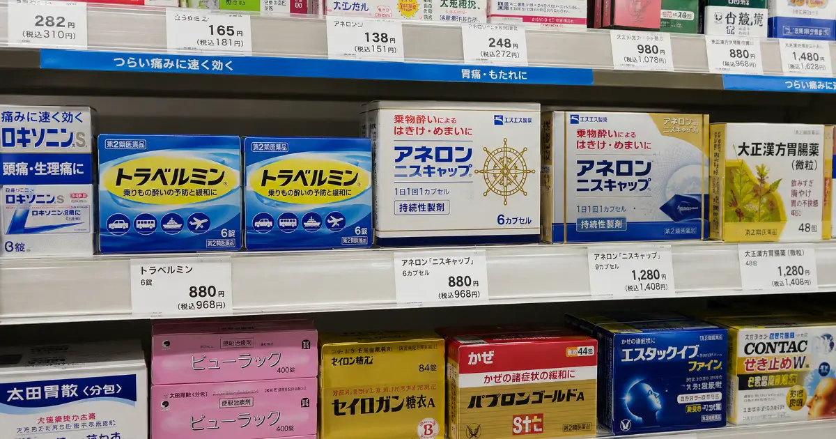 コンビニの医薬品売り場でトラベルミンとアネロンの酔い止めが棚に並んでいる様子