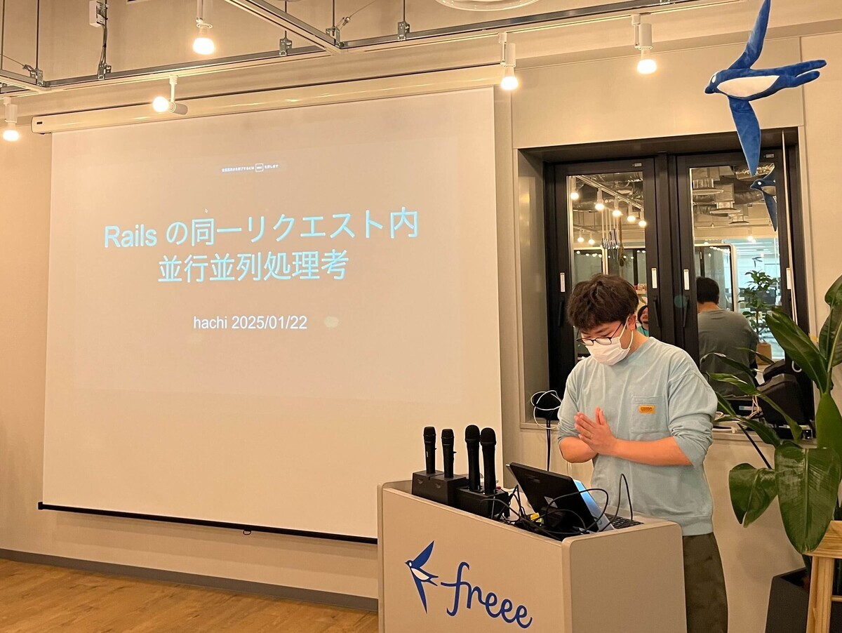 hachi さんの発表している様子。スクリーンには、「Railsの同一リクエスト内並行並列処考」と書かれている