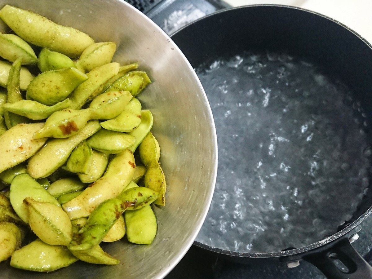 沸騰したお湯に黒豆を入れる様子