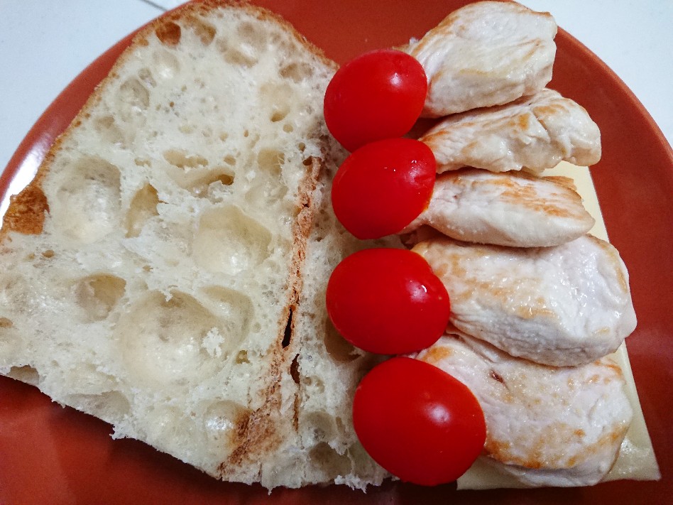 バゲットの上にチーズ、鶏肉、トマト