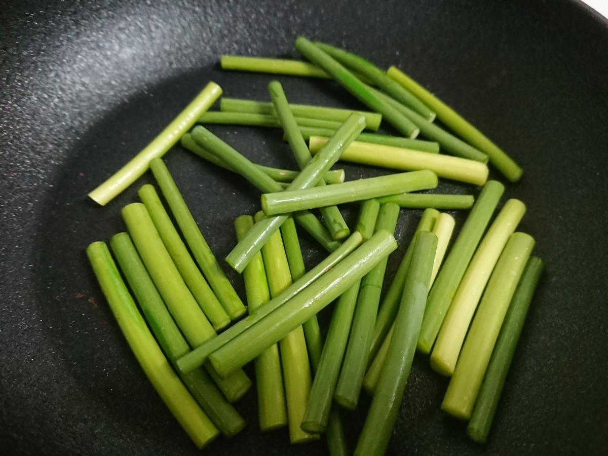 ニンニクの芽をフライパンで焼いている