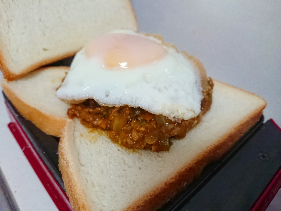 食パンの上にカレーと目玉焼きがのっている