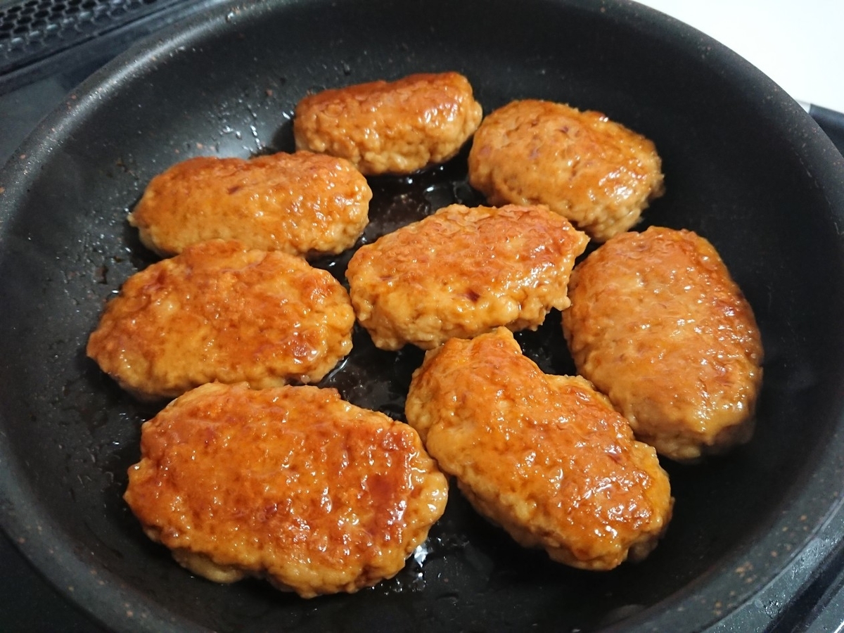 つくねを照り焼きソースに絡めている