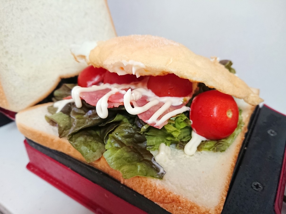 食パンの上にレタス、ベーコン、トマト、目玉焼き