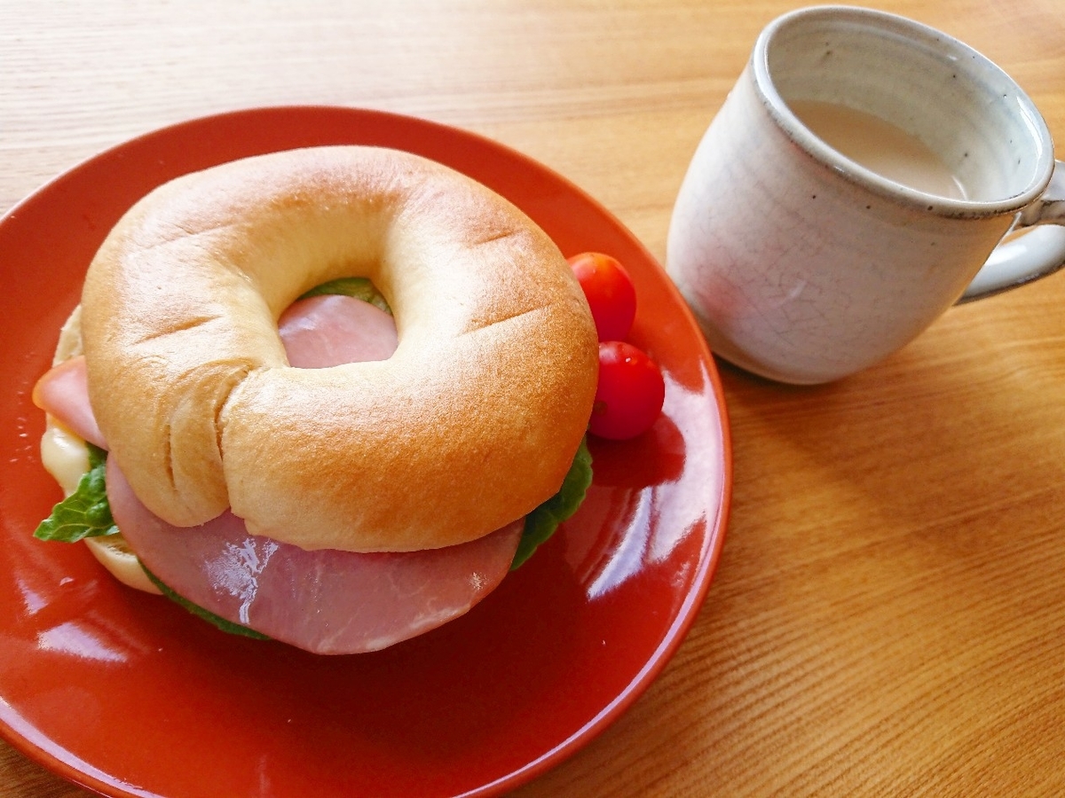 ハム、チーズ、レタスが挟まったベーグル コーヒー牛乳