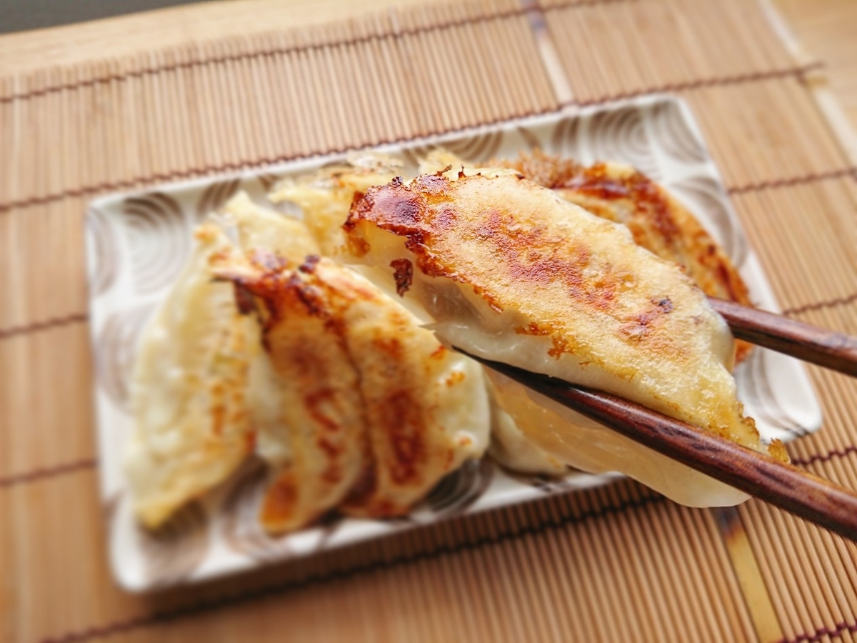 箸で餃子を掴んでいる