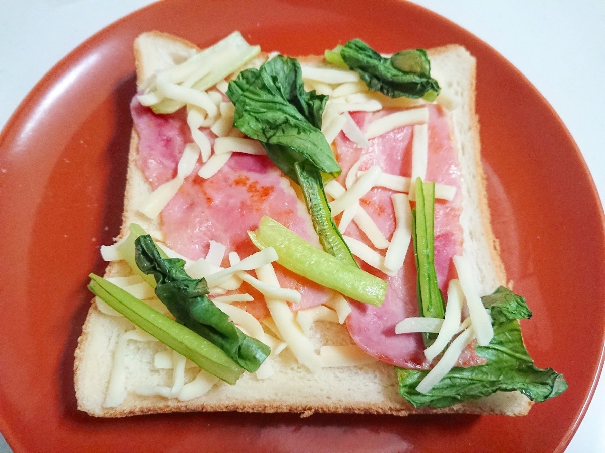 食パンの上に小松菜とベーコンとチーズがのっている