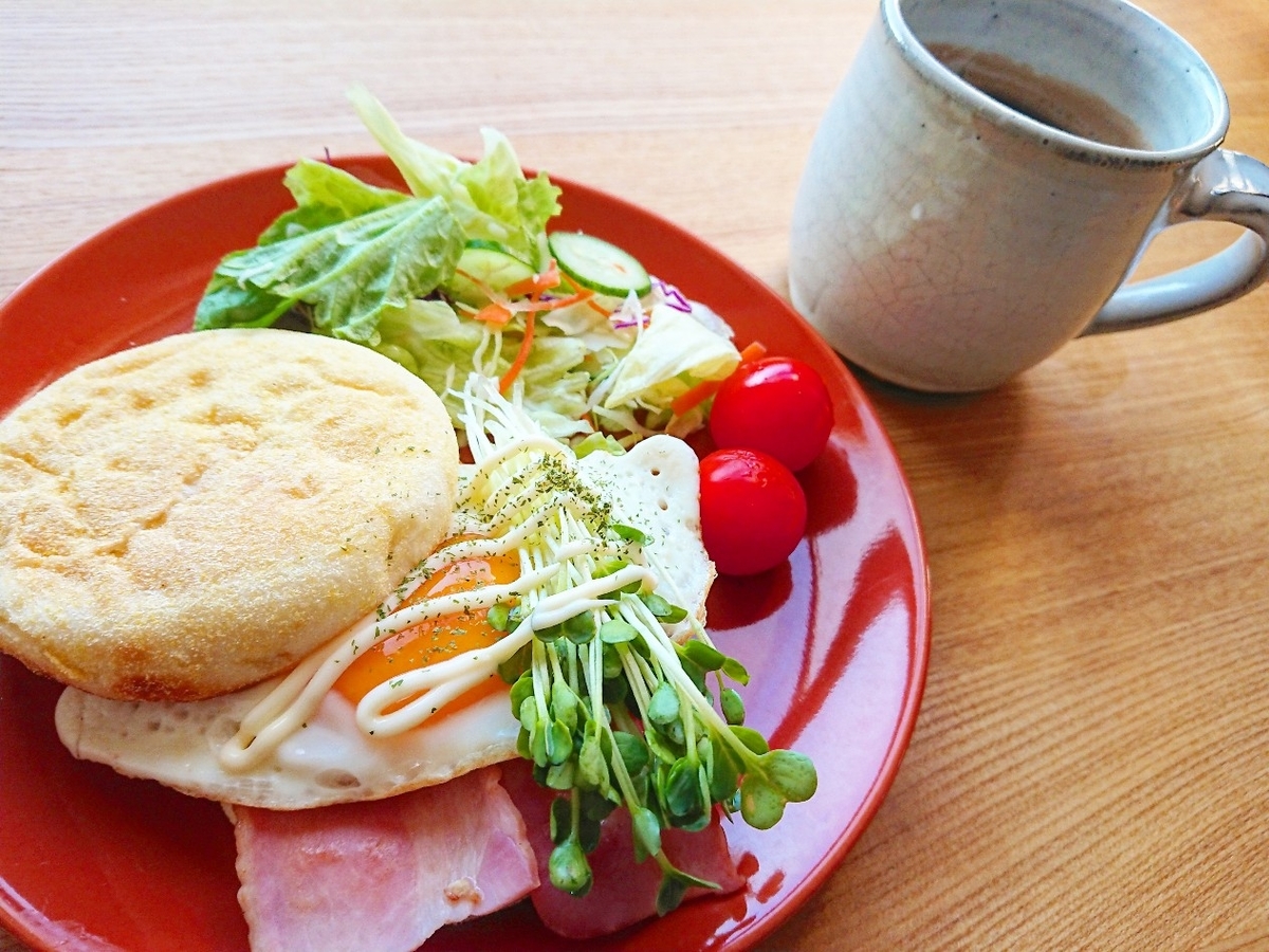ベーコンと目玉焼きが挟まったマフィンサンド サラダ コーヒー