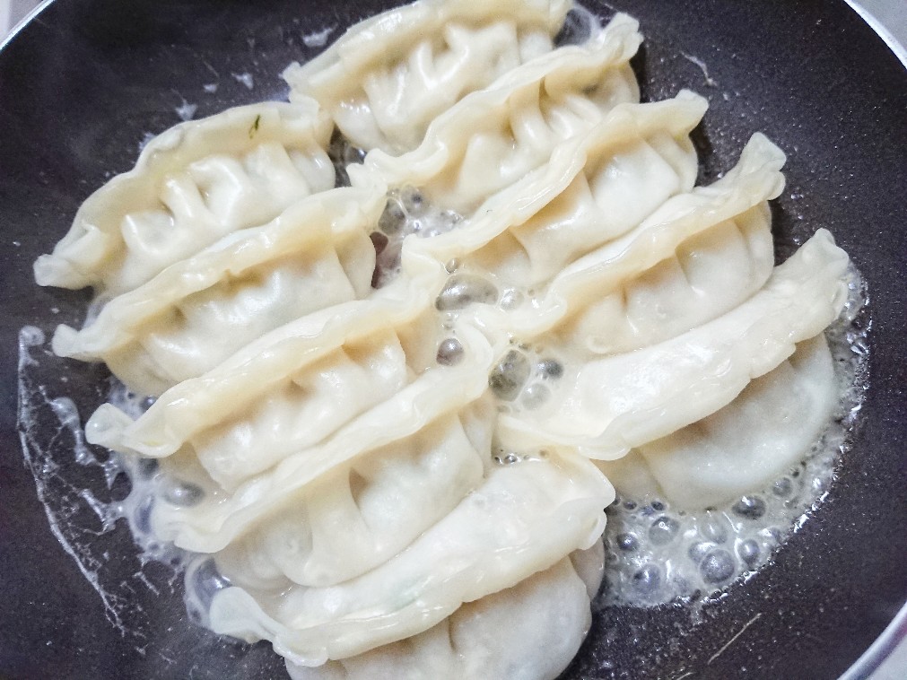 フライパンで餃子を焼いている