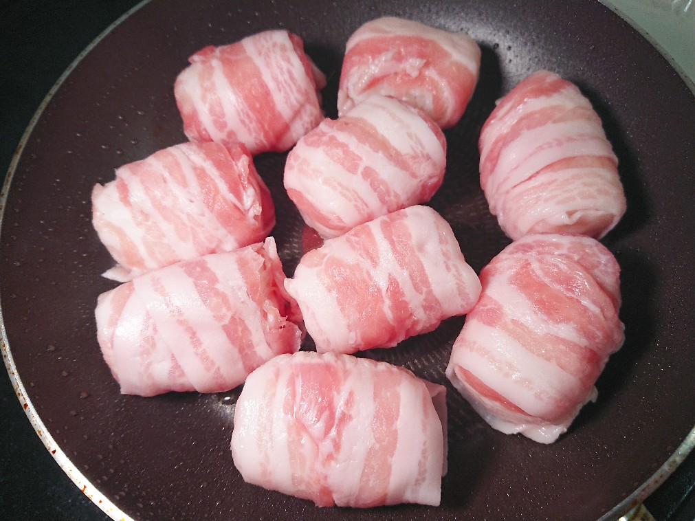 フライパンで肉巻きおにぎりを焼いている