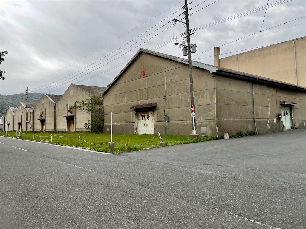 石造の三角屋根の倉庫が通りの向こうに5つ並んでいる写真。手前のは扉に11号と書かれている。