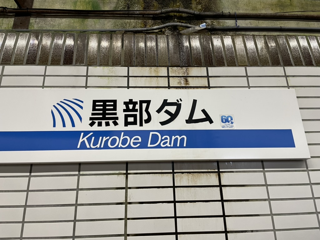 黒部ダムの駅名標、タイルの壁に貼られている