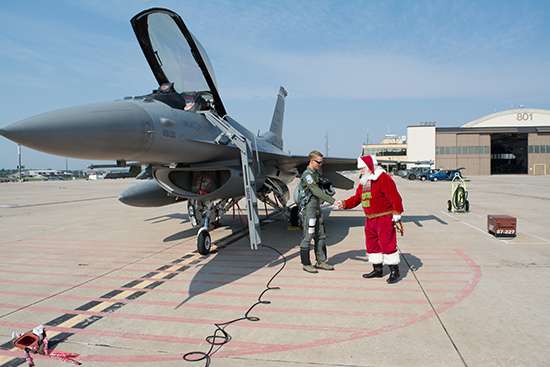 戦闘機の前で握手するサンタと隊員