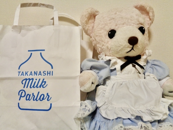 タカナシ・ミルク・パーラーの紙袋の横にいるピンクのテディベア