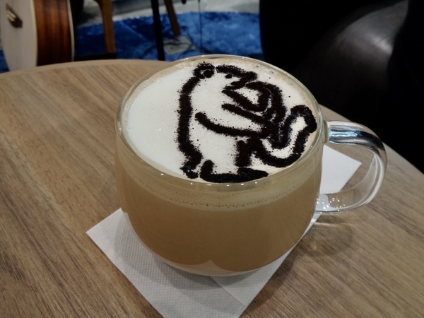 サックスを吹いているくまのラテアートを施したカフェラテ