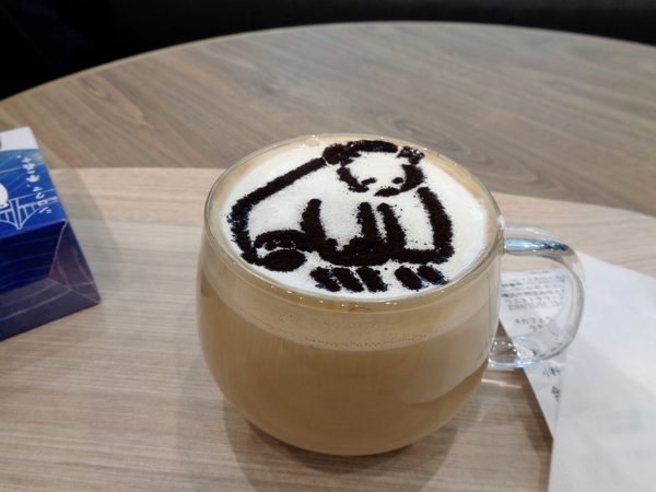 鍵盤を弾いている熊のラテアートがほどこされたカフェラテ