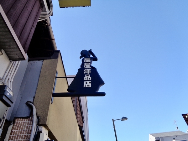 洋品店の看板がドレスを着た人をかたどっている