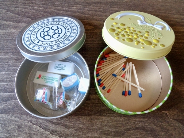 丸い缶がふたつ。片方は砂糖がいくつか、もう片方にはマッチ棒が入っている。