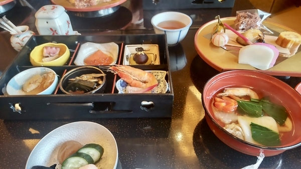 お雑煮や栗きんとん、お赤飯、田作りなどおせち料理がところせましと並んでいる