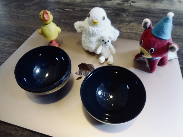 ガチャガチャのケースの写真。ガチャガチャのプラケースのまわりに、小さなぬいぐるみや木彫りの鳥が集まっているところ。