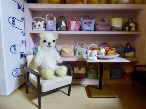 ミニチュアの椅子に座っている小さなくまのぬいぐるみの写真