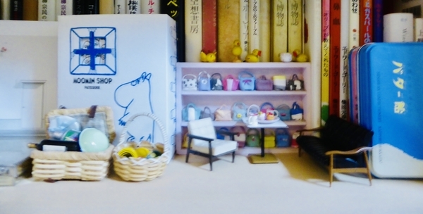 本棚の一隅にミニチュアの家具が置いてある写真