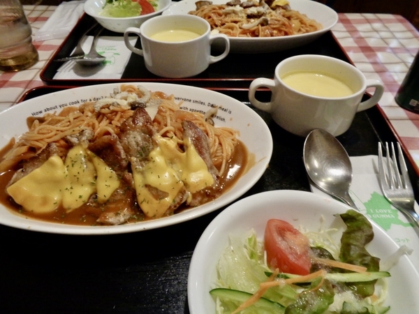 ランチの写真。ナポリタンの上にポークソテー、チーズがのっているものと、サラダ、コーンポタージュ。
