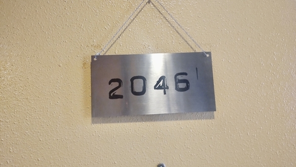 映画館のスタッフルームの扉を撮った写真。「2046」のプレートが下がっている。