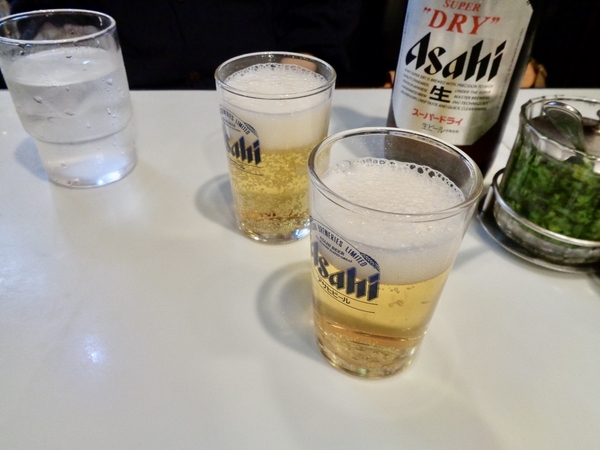 テーブルの上にビールを注いだグラスが二つある写真