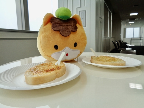 切ったフランスパンの写真。お皿にのったフランスパンをぐんまちゃんが見ている。