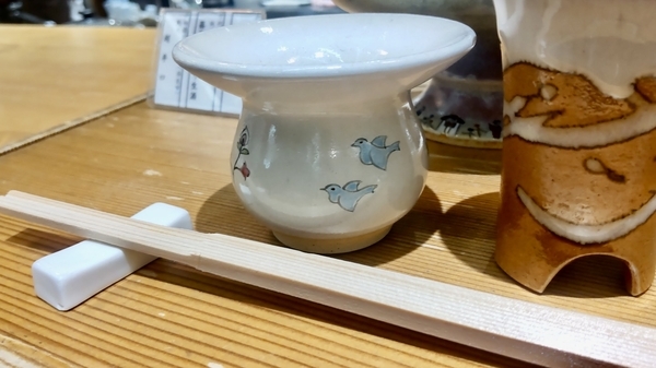 金魚鉢のようなかたちをしたおちょこの写真。鳥の絵がついている。