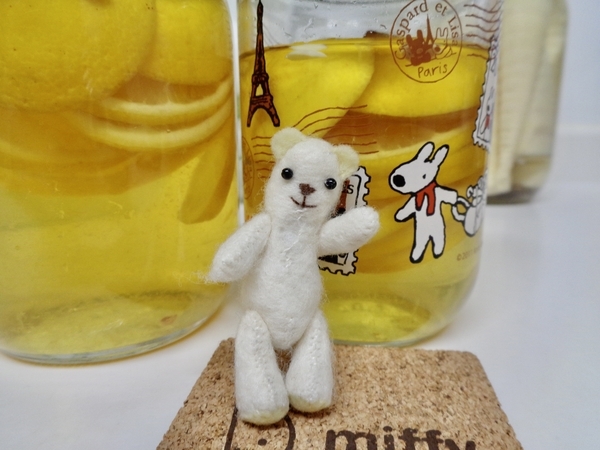 瓶入りのレモン酢の写真。二瓶あって、前にちいさなくまのぬいぐるみが立っている。