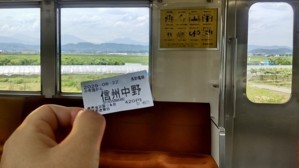 長野電鉄電車内の写真。手に、小布施発信州中野駅行きの切符がある。