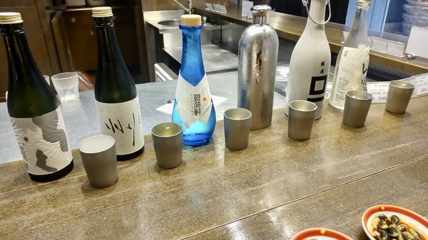お酒の写真。桝一市村酒造場のお酒が五種類、カウンターに出ている。まんなかに水のボトルも出ている。