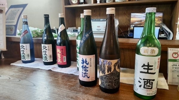 日本酒の写真。北信流など、四合瓶がカウンターの上に6本並んでいる。