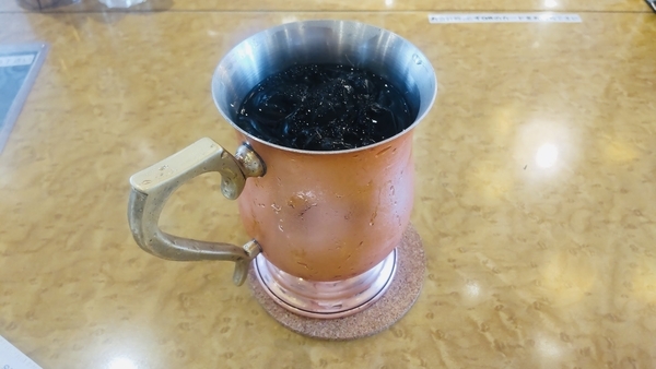 銅製のカップに入ったアイスコーヒーの写真